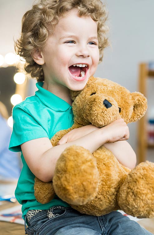 Child Hugging Teddy Bear During Joyful Learning Experience